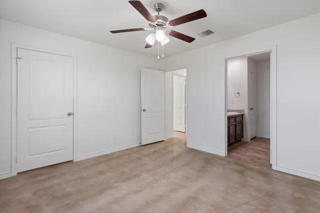 an empty room with a window and a fan