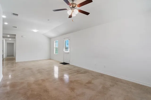 an empty room with a ceiling fan and a window