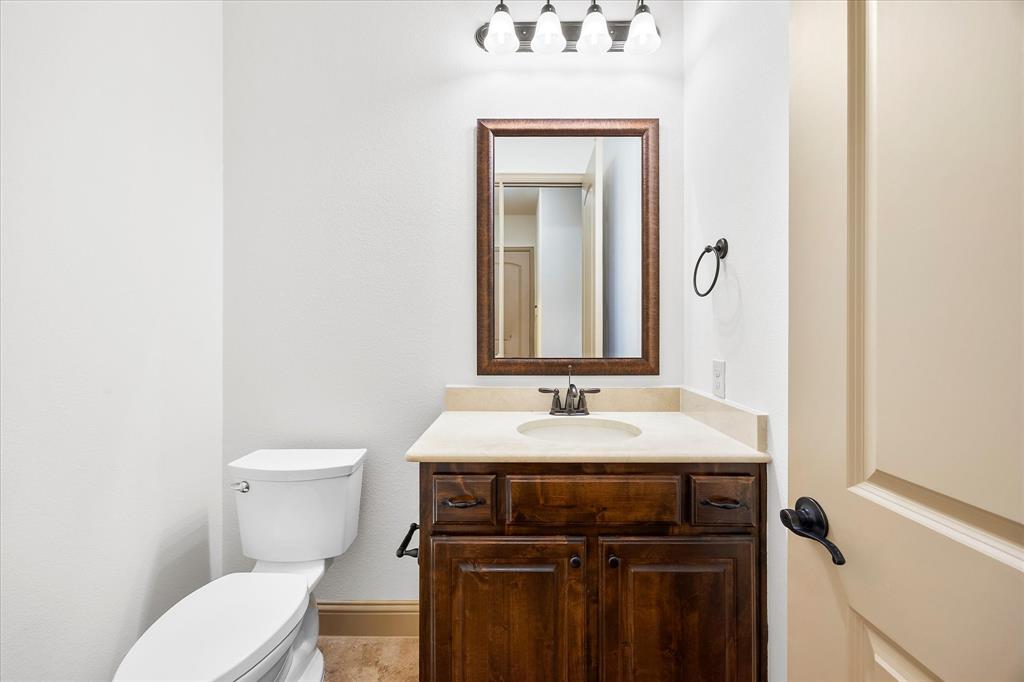 6814 Springwood Lane Garland, TX 75044 - Photo 26 of 35 a bathroom with a toilet sink and mirror