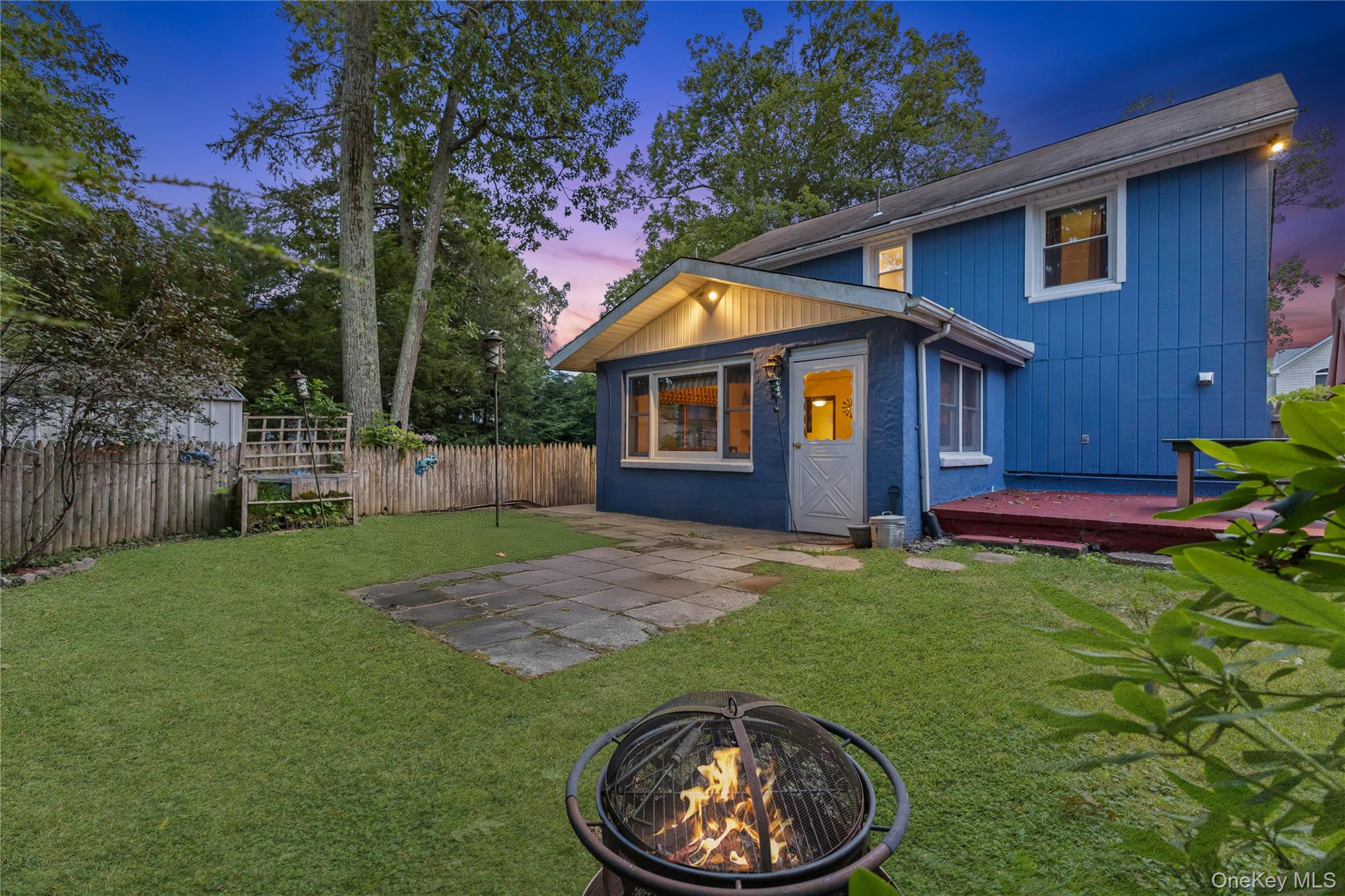 11 Orleans Road Patterson, NY 12563 - Photo 16 of 23 Back view of sunroom and property with an outdoor fire pit, a patio area