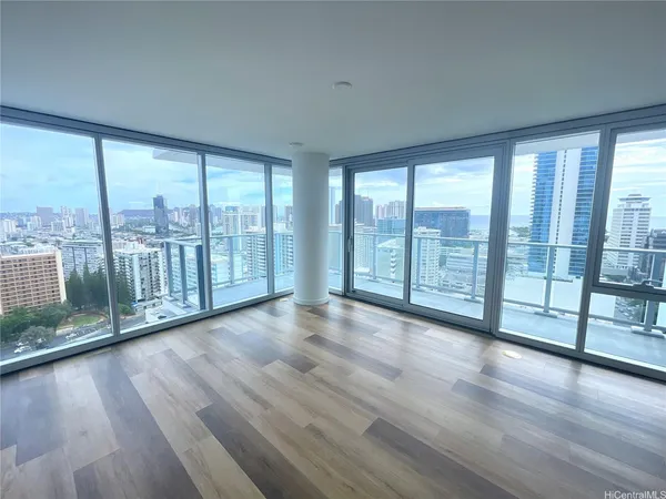 a view of empty room with wooden floor and floor to ceiling window