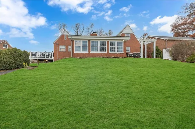 a view of a yard in front of a house with a large tree