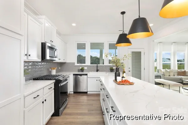 a kitchen with stove a sink and a refrigerator