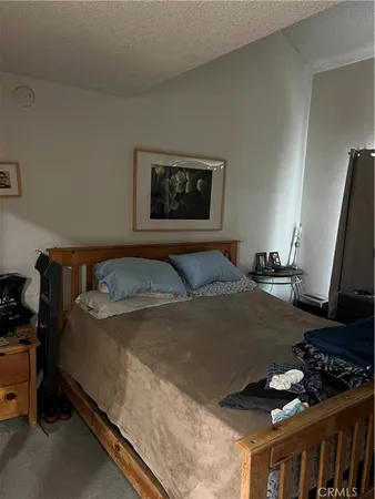 a bedroom with a bed and a flat tv screen on the dresser