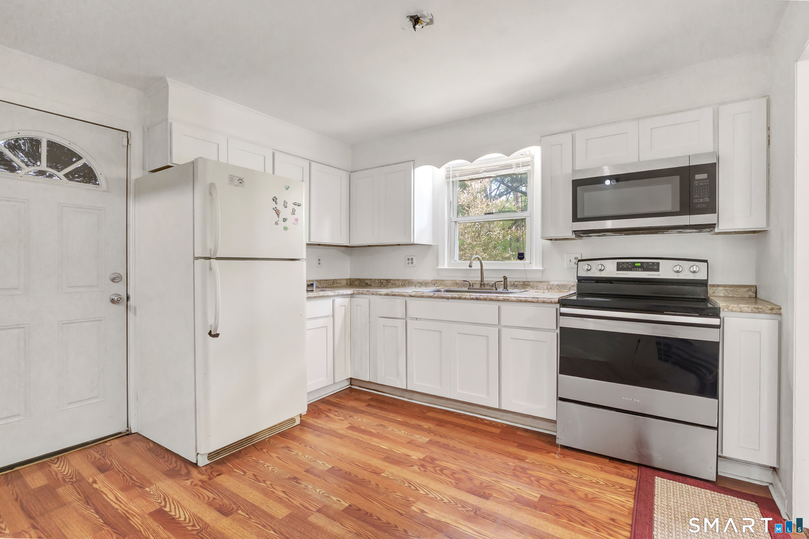 136 Harrison Drive Hamden, CT 06514 - Photo 9 of 20 a kitchen with cabinets stainless steel appliances and wooden floor