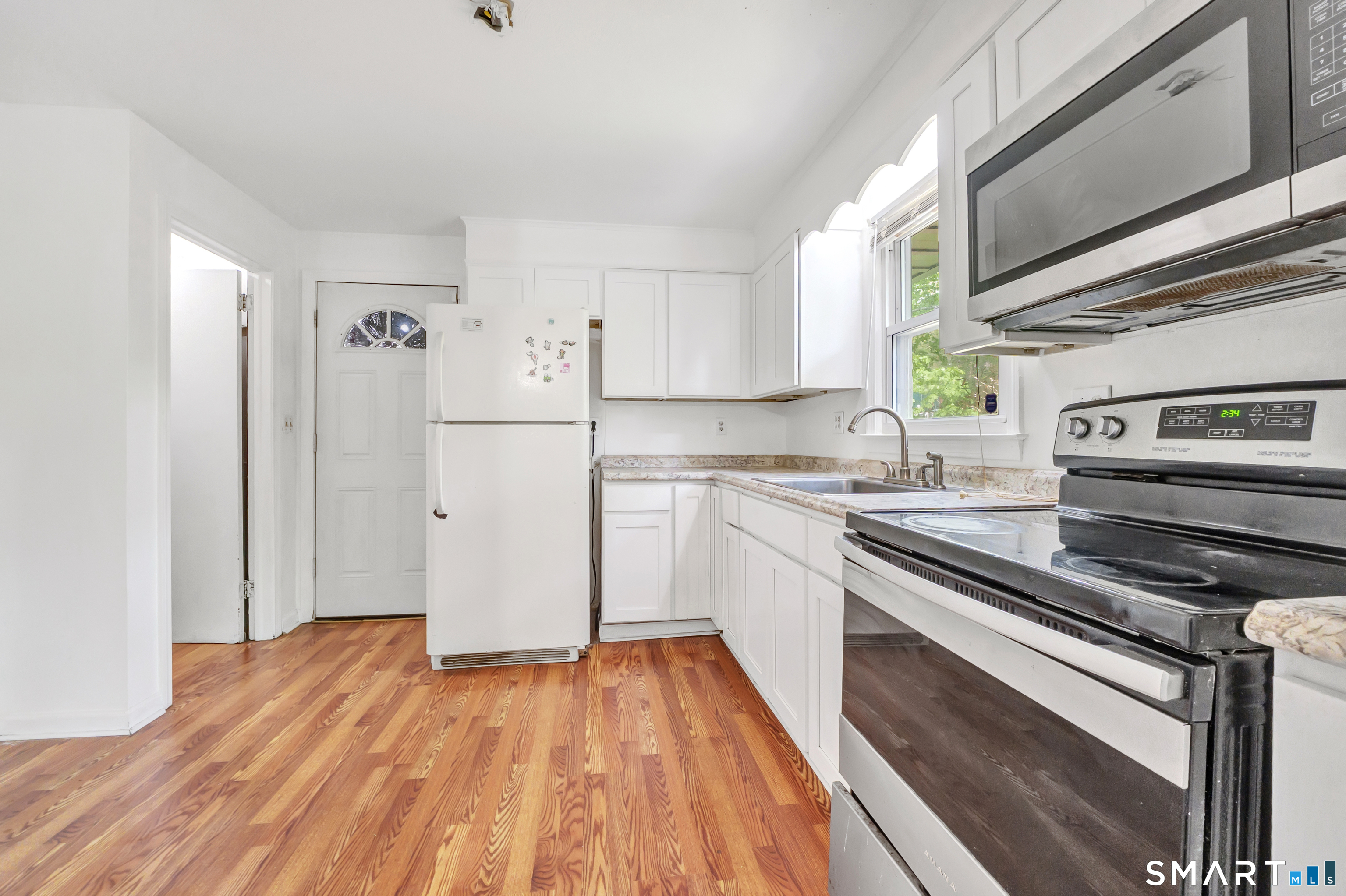 136 Harrison Drive Hamden, CT 06514 - Photo 10 of 20 a kitchen with a refrigerator stove and wooden floor