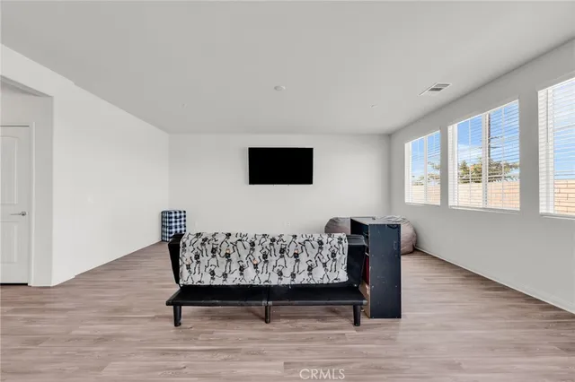 a living room with furniture and kitchen view with wooden floor