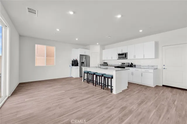 a kitchen with granite countertop a stove top oven sink and cabinets