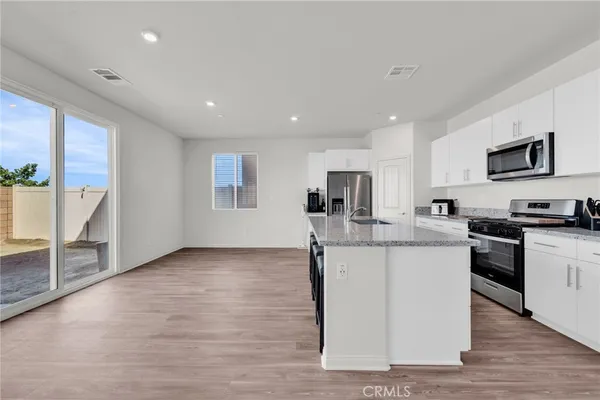 a large kitchen with stainless steel appliances granite countertop a stove top oven a sink and dishwasher