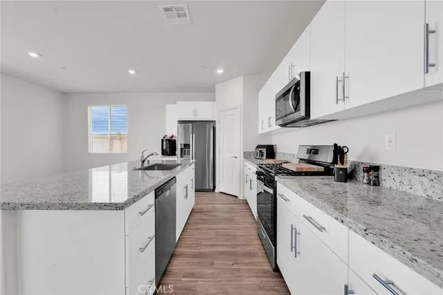 a kitchen with sink a microwave and refrigerator