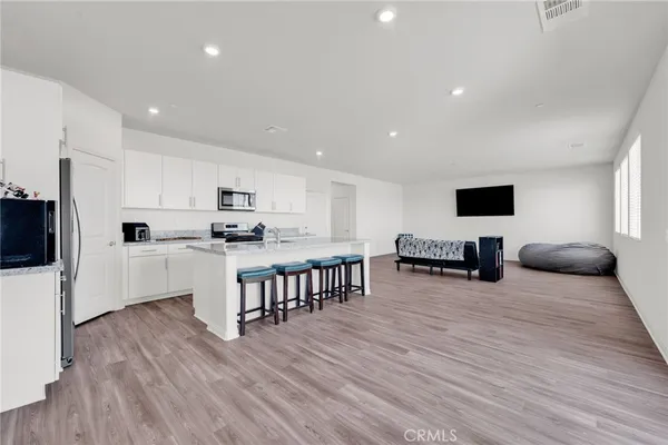 a kitchen with white cabinets stainless steel appliances and wooden floor