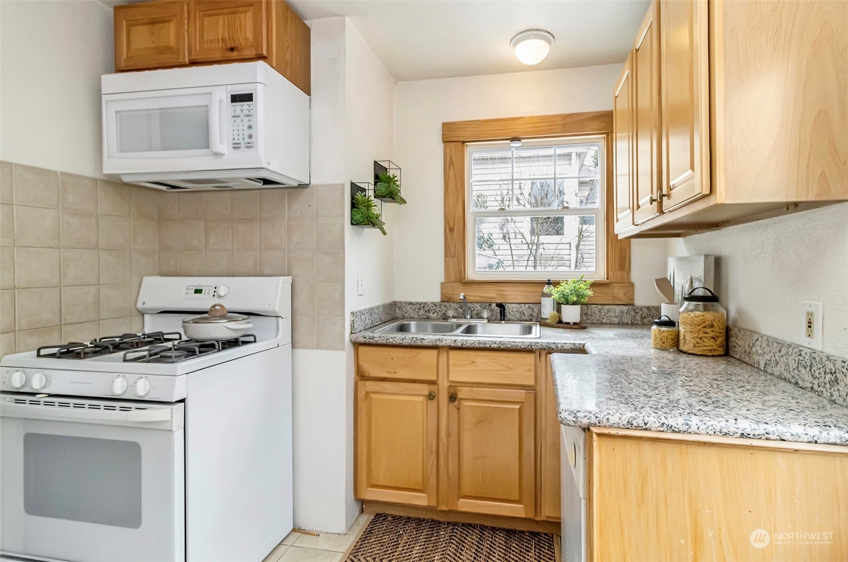 9048 3rd Avenue South Seattle, WA 98108 - Photo 14 of 36 a kitchen with granite countertop a sink stove and cabinets