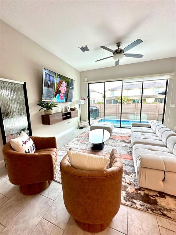 136 Villa Domani Circle Davenport, FL 33896 - Photo 2 of 9 a living room with furniture and a flat screen tv