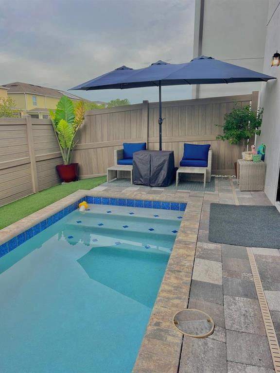 136 Villa Domani Circle Davenport, FL 33896 - Photo 6 of 9 a view of a patio with table and chairs potted plants with wooden floor