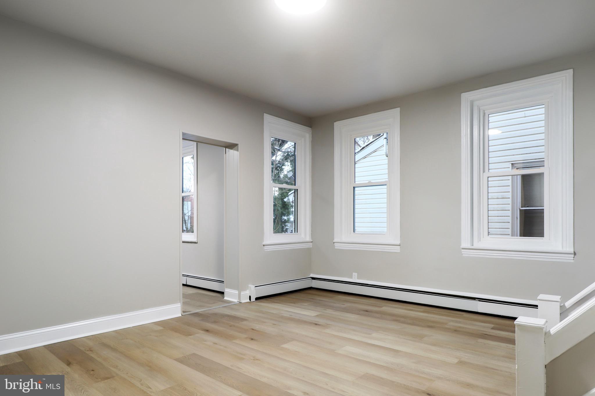77 7th Street Salem, NJ 08079 - Photo 2 of 15 an empty room with wooden floor and windows