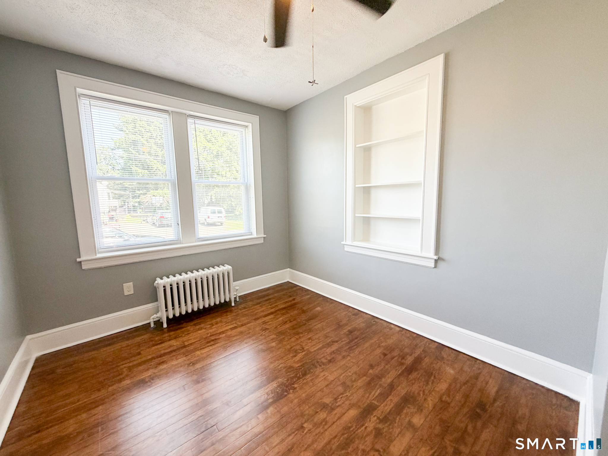 793 Milford Point Road, Unit 1 Milford, CT 06460 - Photo 10 of 16 a view of empty room with wooden floor and fan