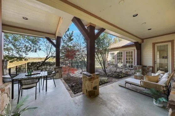 a living room with patio furniture and a floor to ceiling window