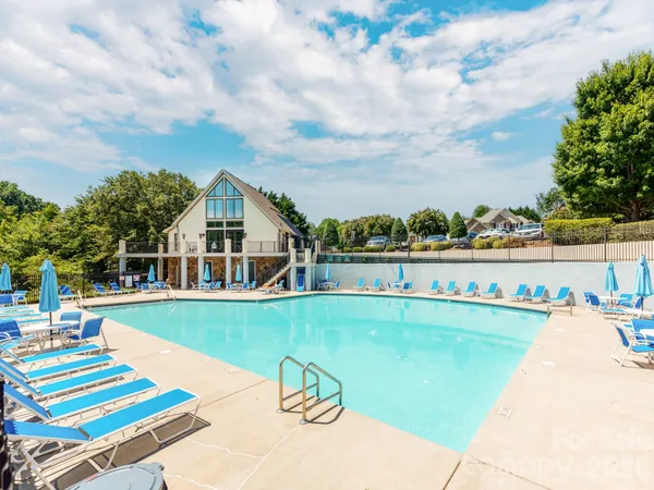 a view of a house with swimming pool and sitting area