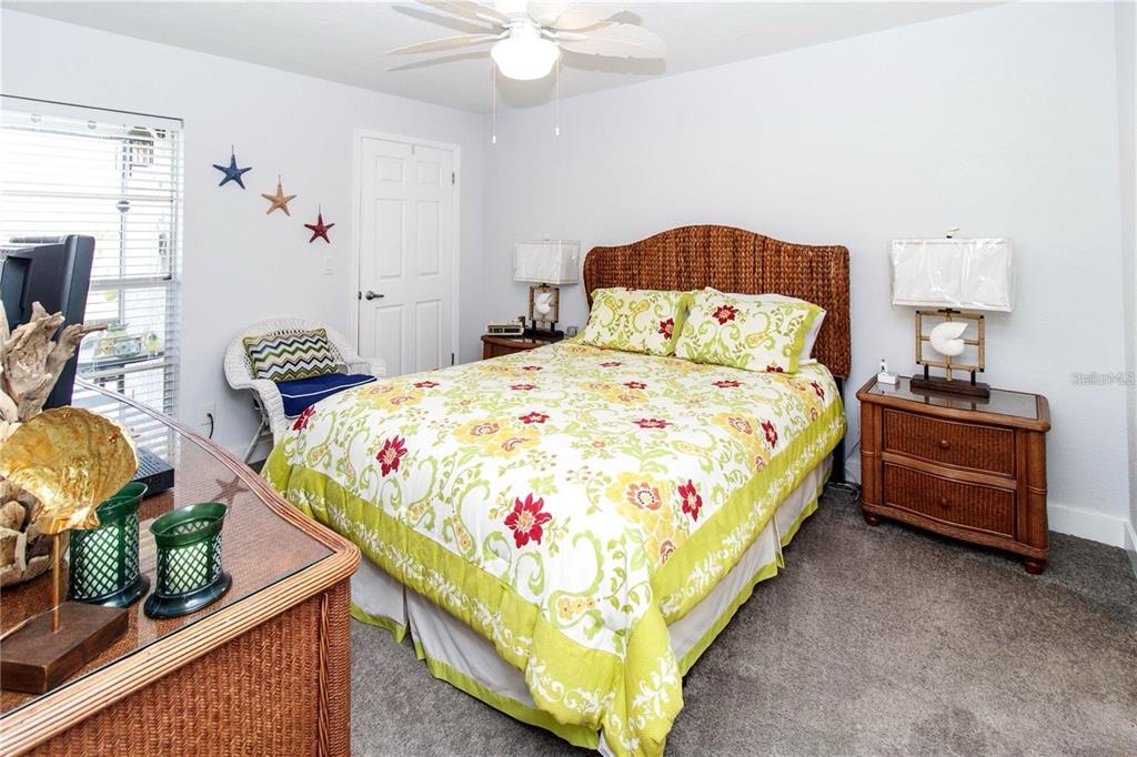 5135 Gemstone Drive, Unit 202 New Port Richey, FL 34652 - Photo 11 of 21 a bedroom with bed and a chandelier
