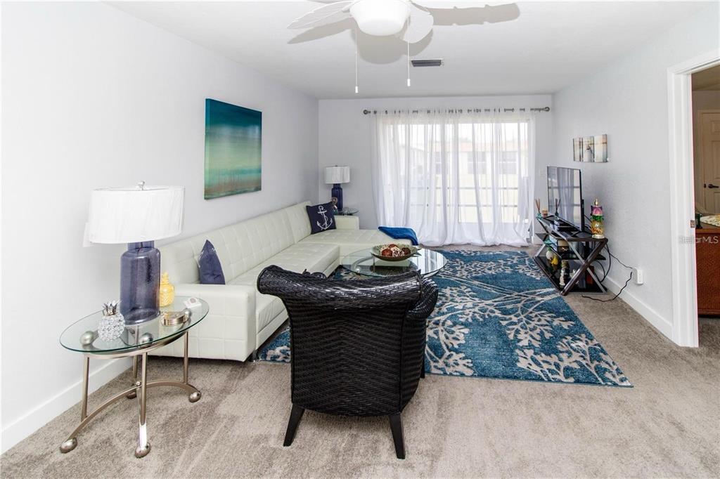 5135 Gemstone Drive, Unit 202 New Port Richey, FL 34652 - Photo 5 of 21 a bed room with a bed and a lamp