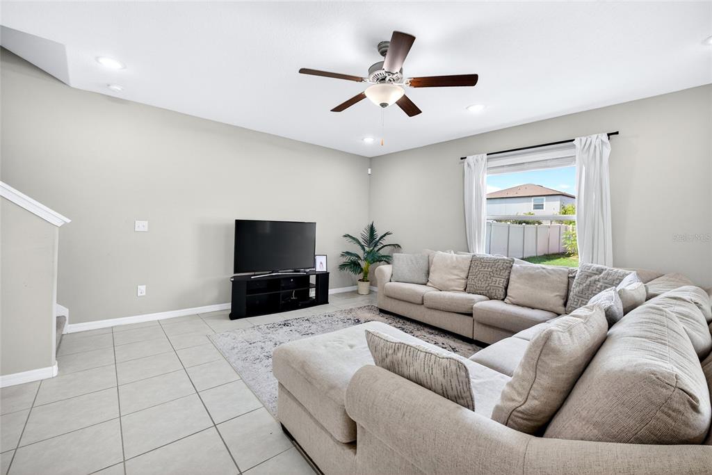 31724 Sun Kettle Loop Wesley Chapel, FL 33545 - Photo 14 of 49 a living room with furniture and a flat screen tv with wooden floor
