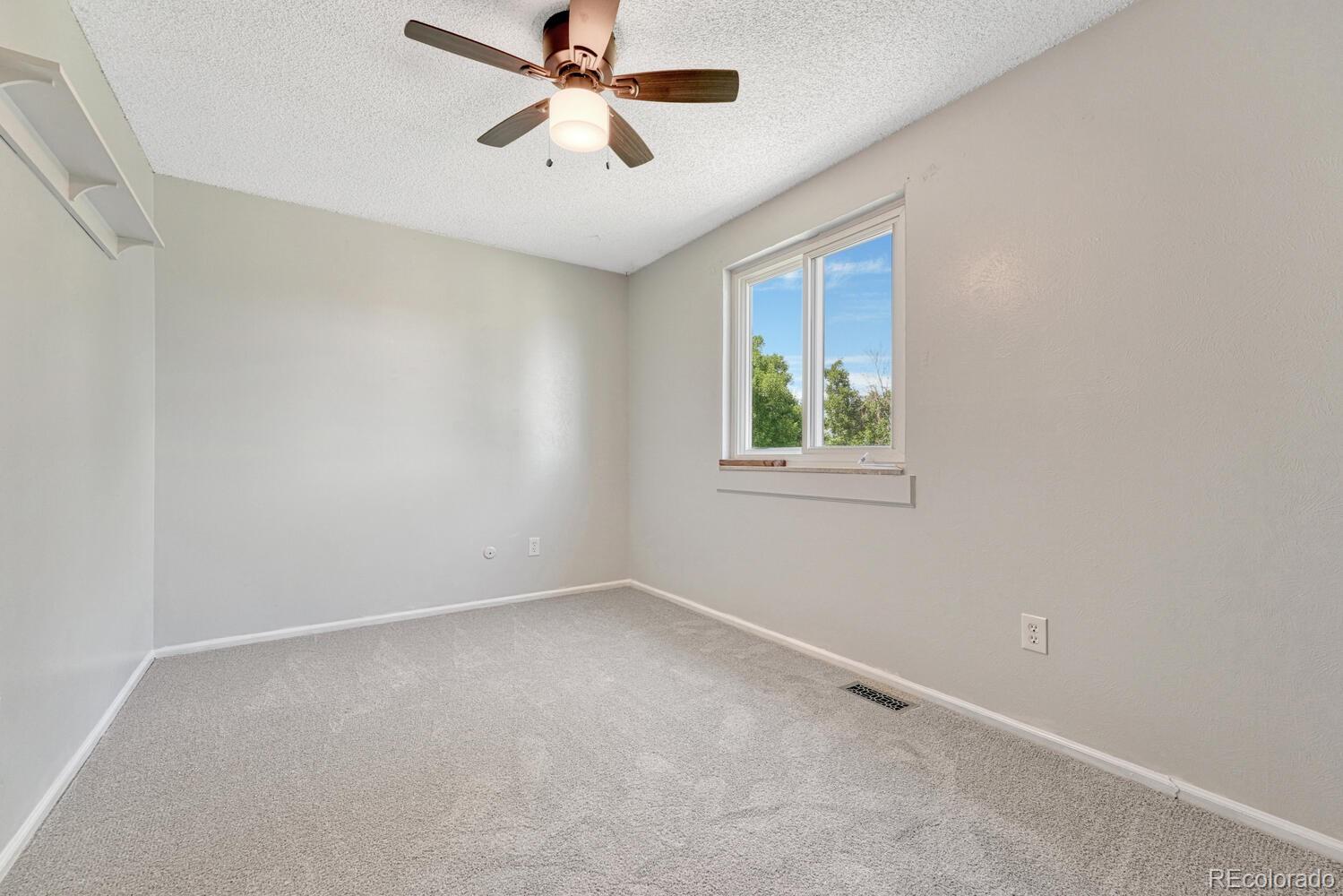11275 Ash Circle Thornton, CO 80233 - Photo 24 of 38 an empty room with windows and fan