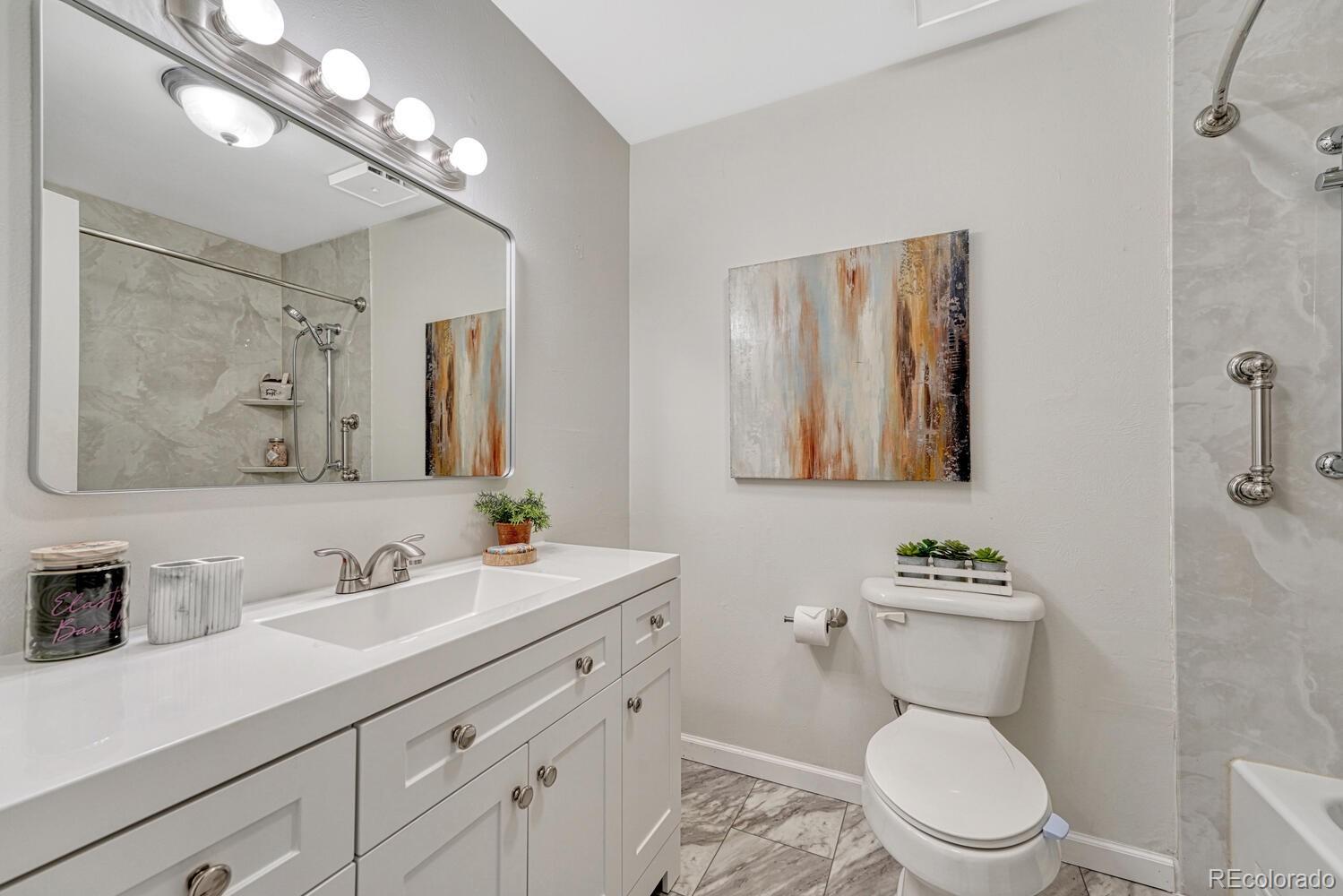 11275 Ash Circle Thornton, CO 80233 - Photo 26 of 38 a bathroom with a toilet a sink and mirror