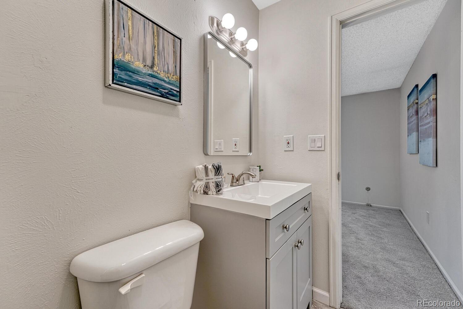11275 Ash Circle Thornton, CO 80233 - Photo 27 of 38 a bathroom with a toilet sink and mirror