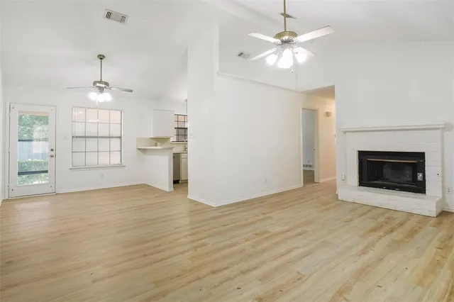 wooden floor fireplace and windows in an empty room