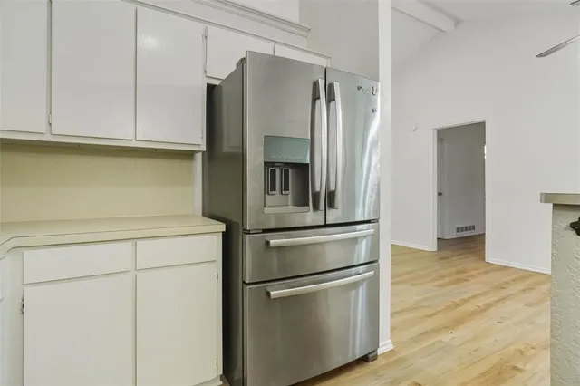 a kitchen with stainless steel appliances white cabinets and a refrigerator