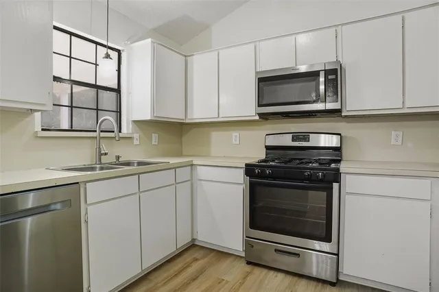 a kitchen with stainless steel appliances granite countertop a stove microwave and sink