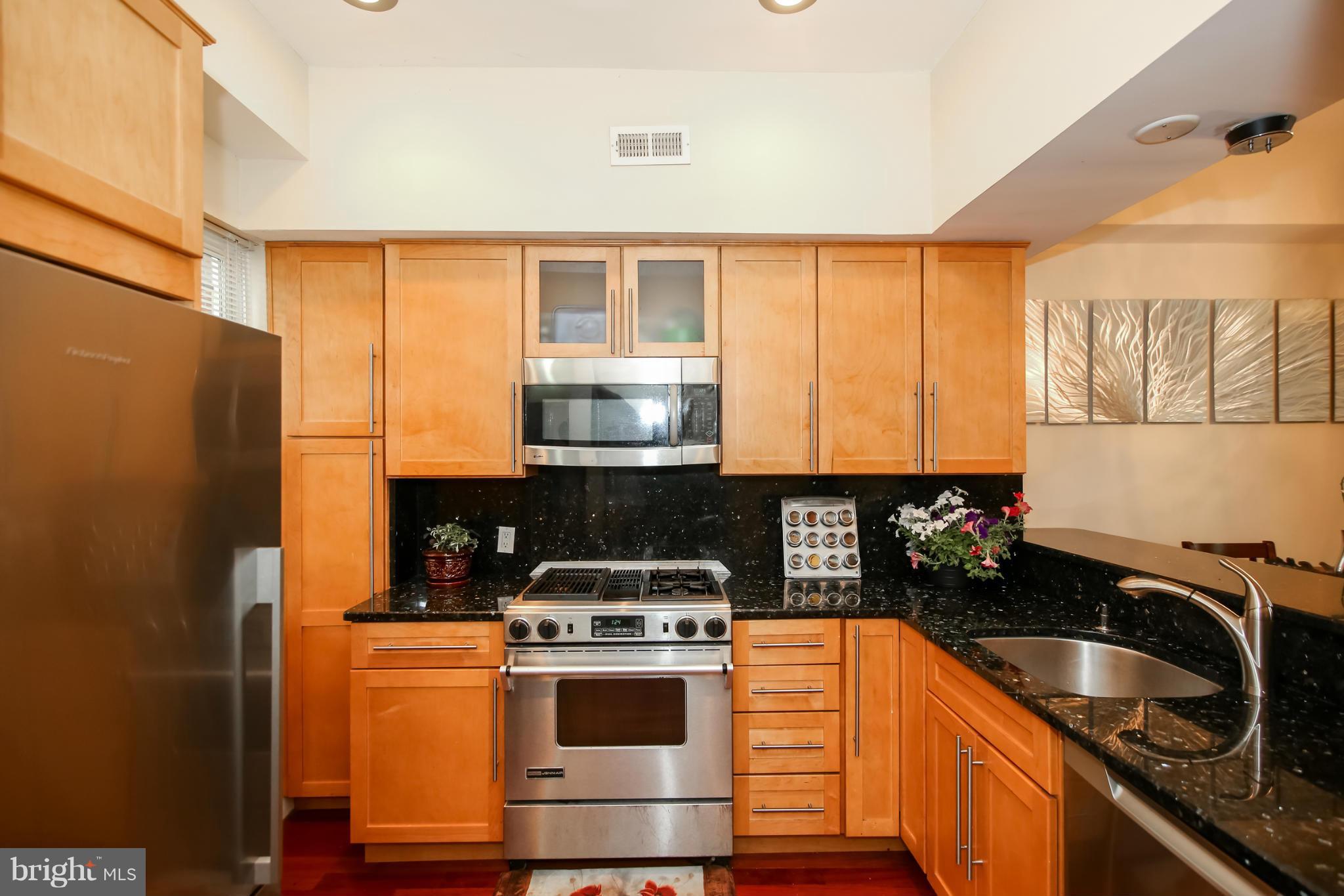 1608 4th Street Northwest Washington, DC 20001 - Photo 6 of 24 a kitchen with stainless steel appliances granite countertop a stove a sink and a refrigerator