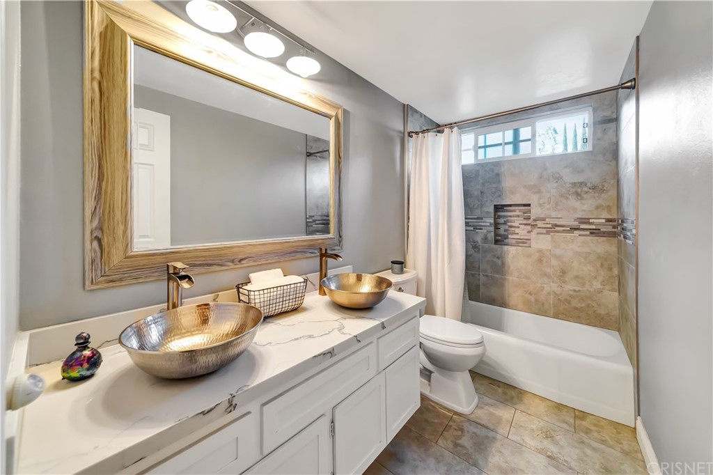 7078 Deveron Ridge Road West Hills, CA 91307 - Photo 29 of 62 a bathroom with a granite countertop sink a toilet a mirror and shower