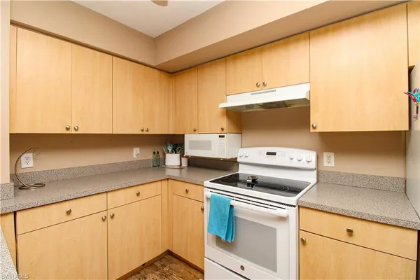 a kitchen with a stove and a white cabinets