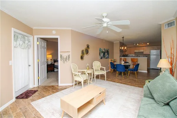 a living room with furniture a chandelier and a dining table