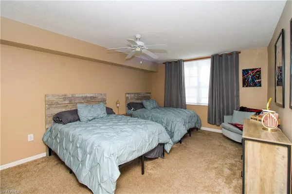 a bedroom with two beds and a chandelier