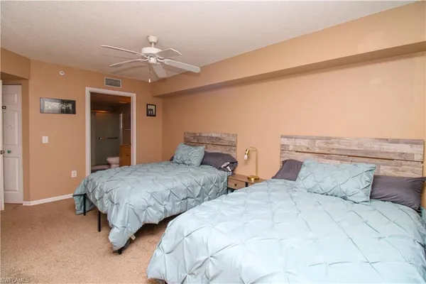 a bedroom with two beds and a chandelier