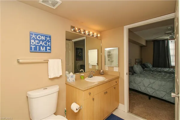 a en suite bathroom with a granite countertop sink and a mirror