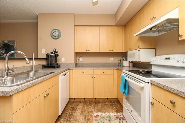 a kitchen with granite countertop a sink a stove and cabinets