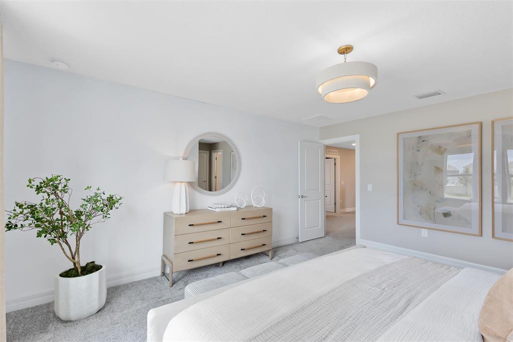 15130 Willow Ridge Drive Montverde, FL 34756 - Photo 17 of 27 a spacious bedroom with a bed and a potted plant