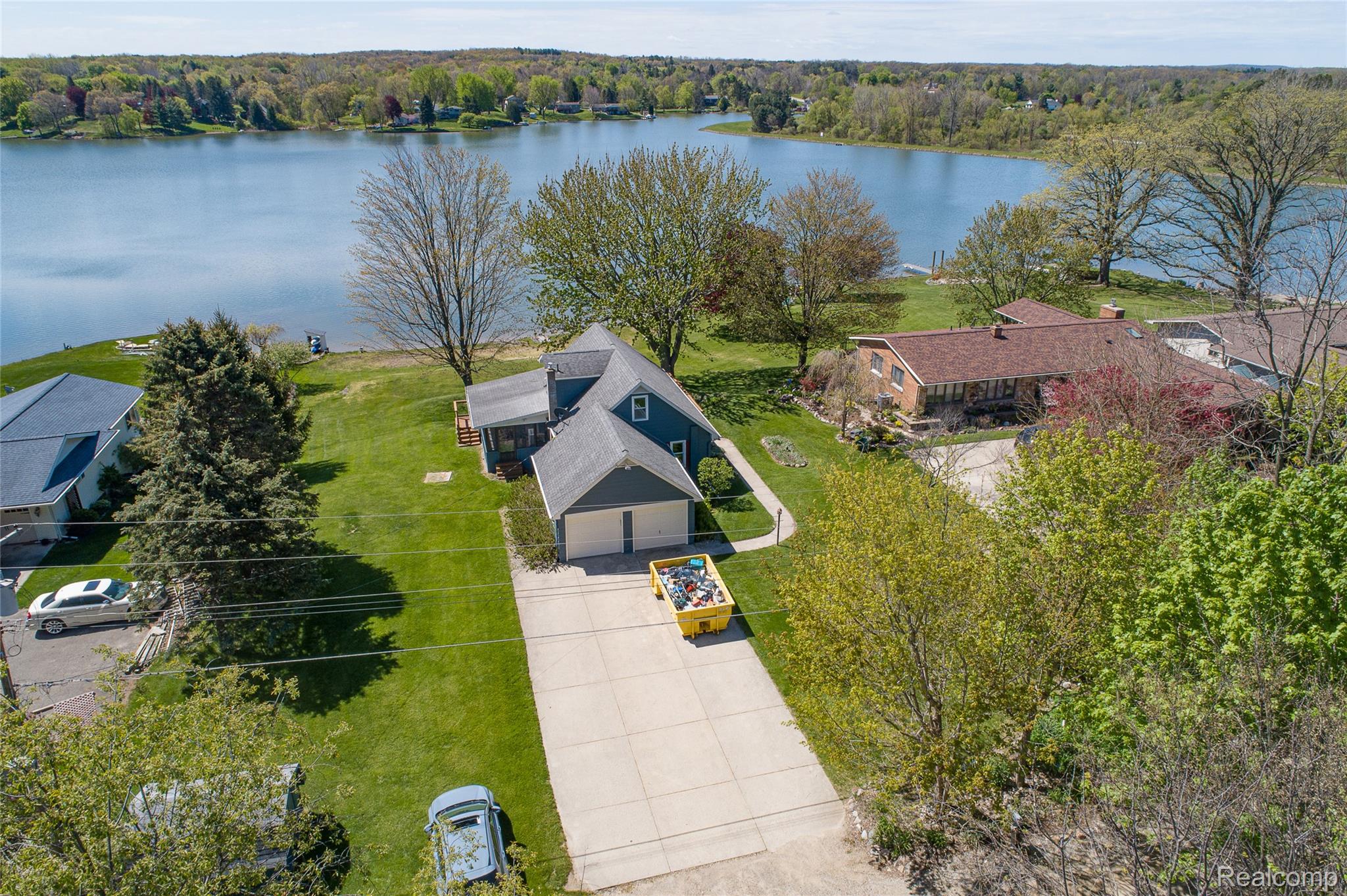 2855 Farmers Creek Road Metamora, MI 48455 - Photo 41 of 51 Waterfront property featuring a two-car garage, mature trees, and a spacious green lawn extending to the water's edge
