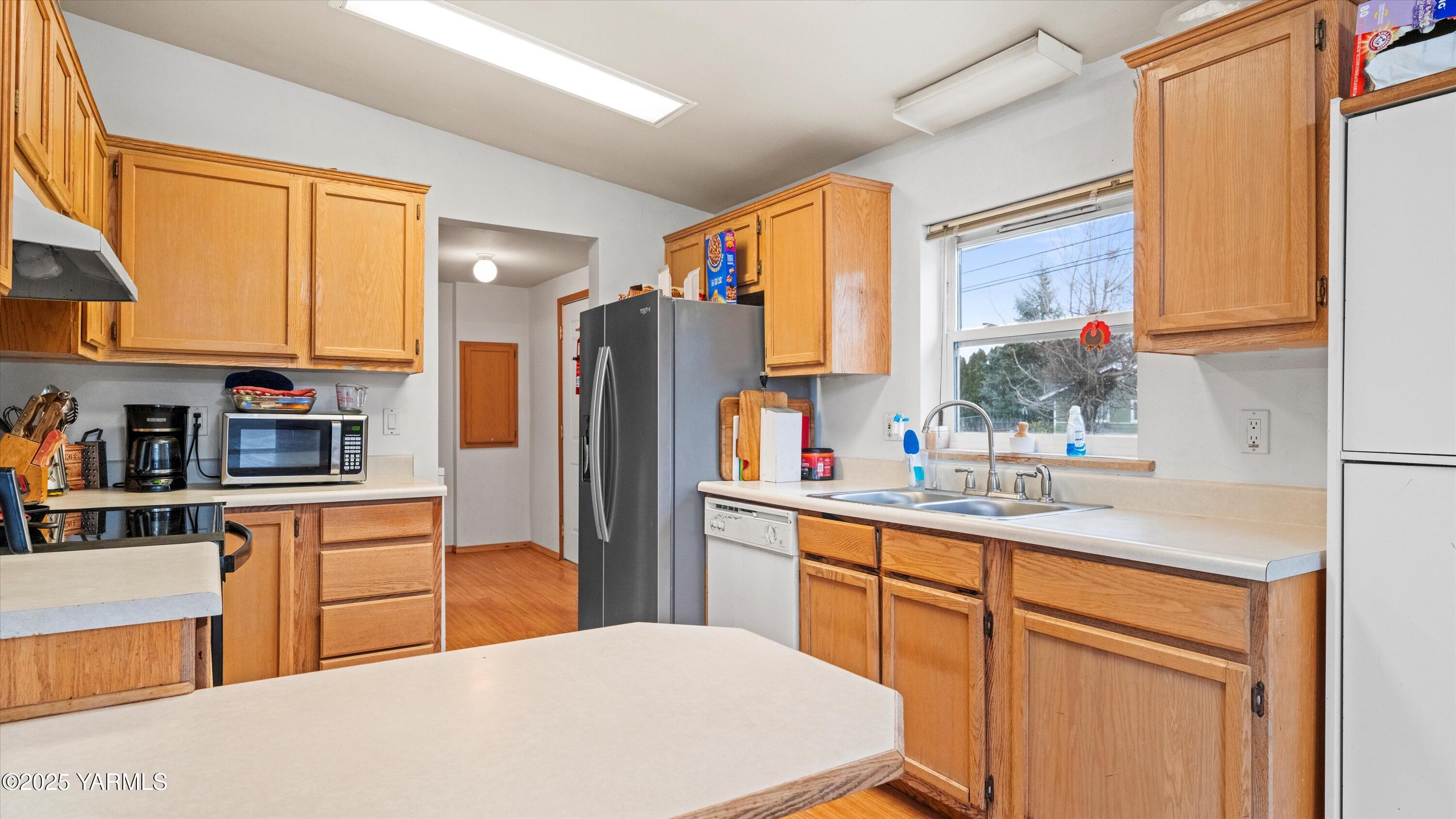 a kitchen with stainless steel appliances a sink cabinets and a refrigerator
