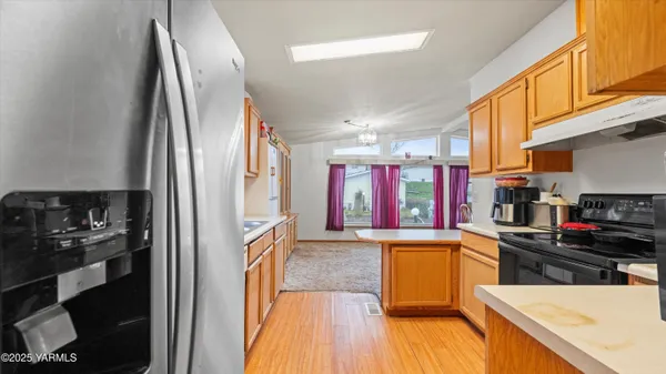 a kitchen with stainless steel appliances granite countertop a refrigerator and a stove top oven