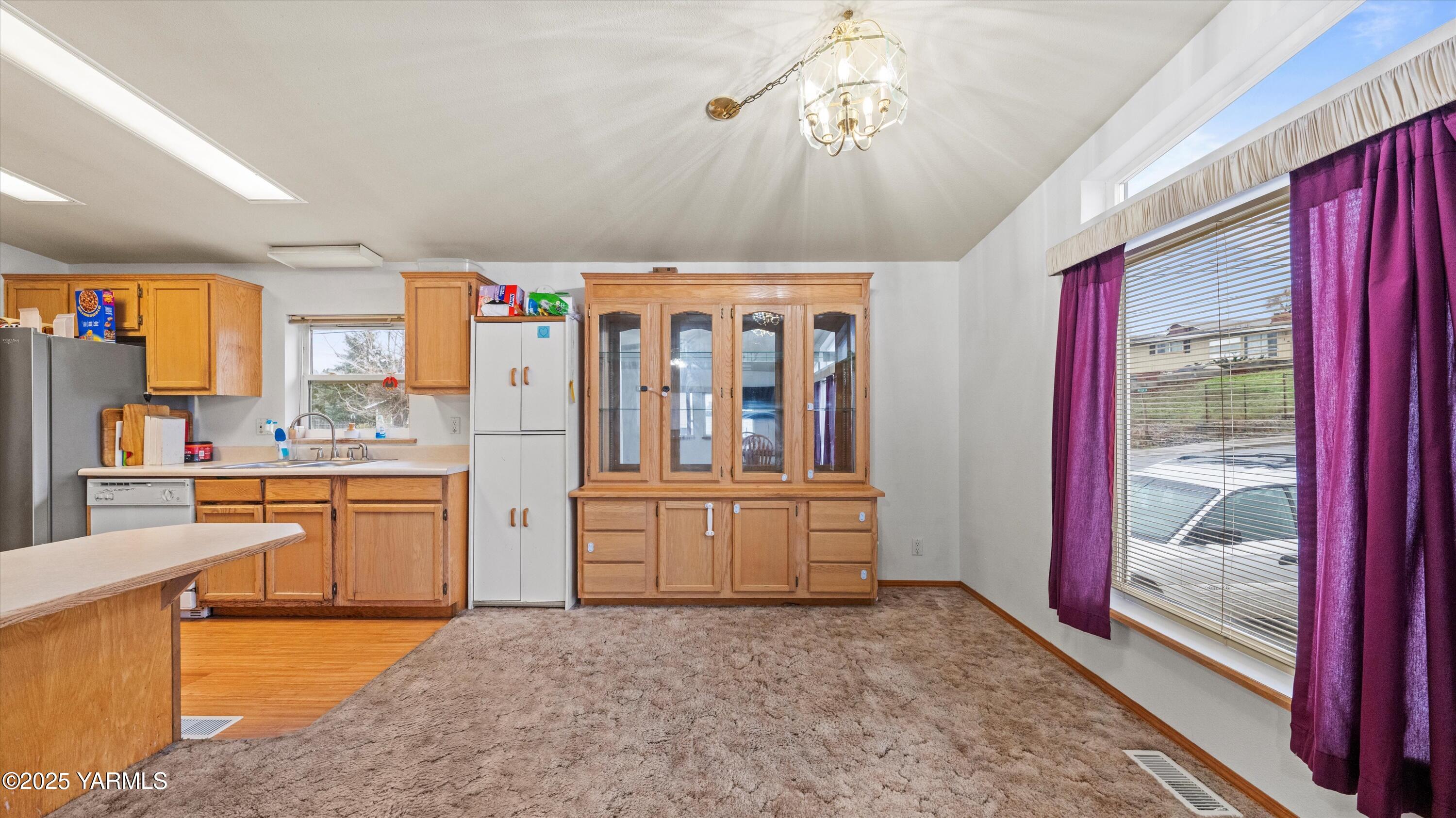 1200 Euclid Street, Unit 76 Grandview, WA 98930 - Photo 24 of 25 a large kitchen with stainless steel appliances granite countertop a refrigerator a stove a sink dishwasher and wooden cabinets with wooden floor
