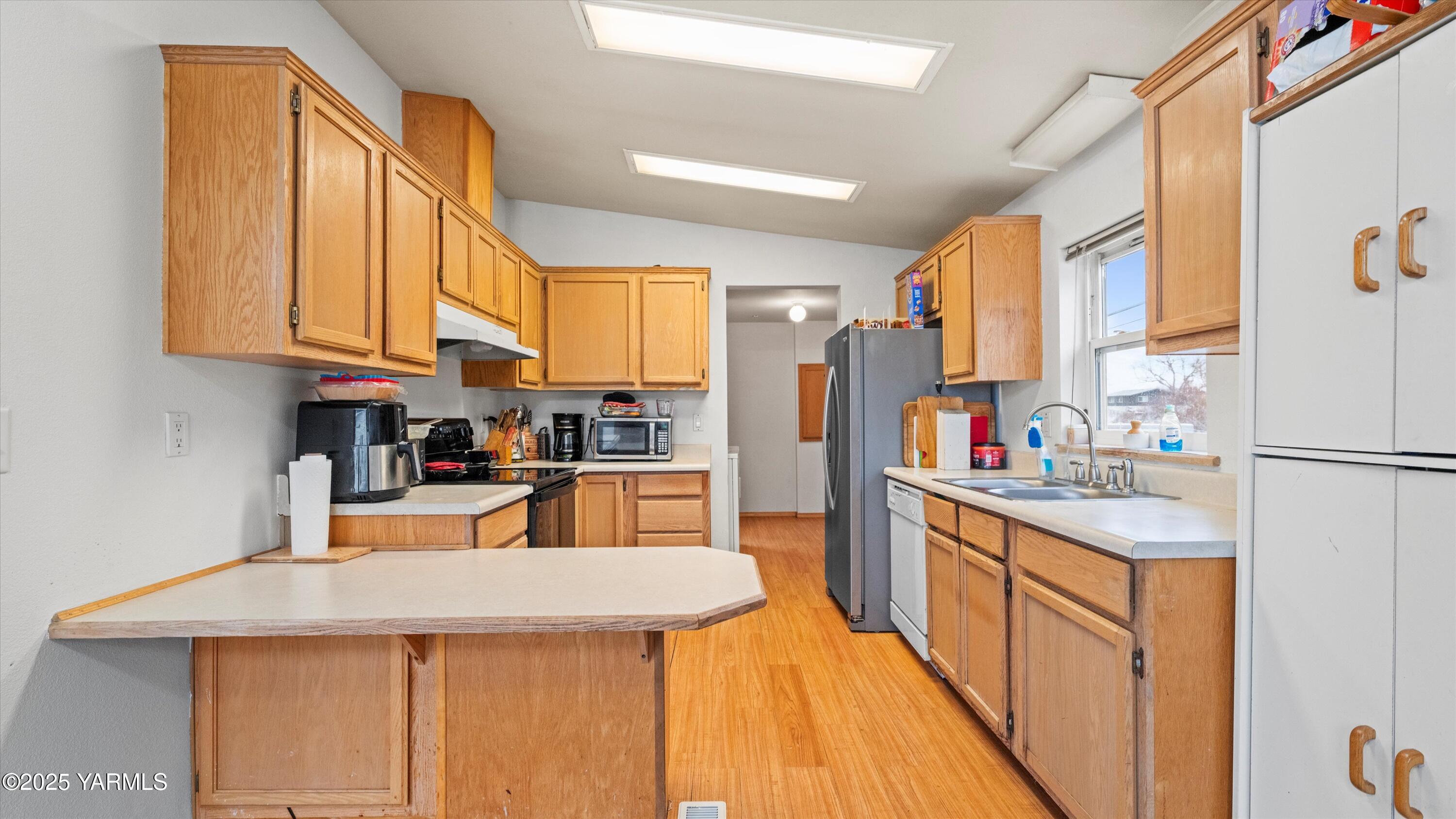 1200 Euclid Street, Unit 76 Grandview, WA 98930 - Photo 25 of 25 a kitchen with stainless steel appliances kitchen island granite countertop a refrigerator a stove and a sink with cabinets