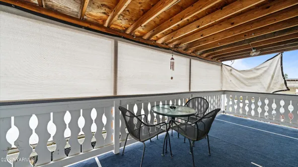 a view of wooden chairs in a balcony