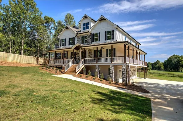 an empty room with wooden floor fireplace and windows
