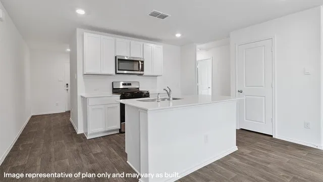 a kitchen with cabinets and wooden floor