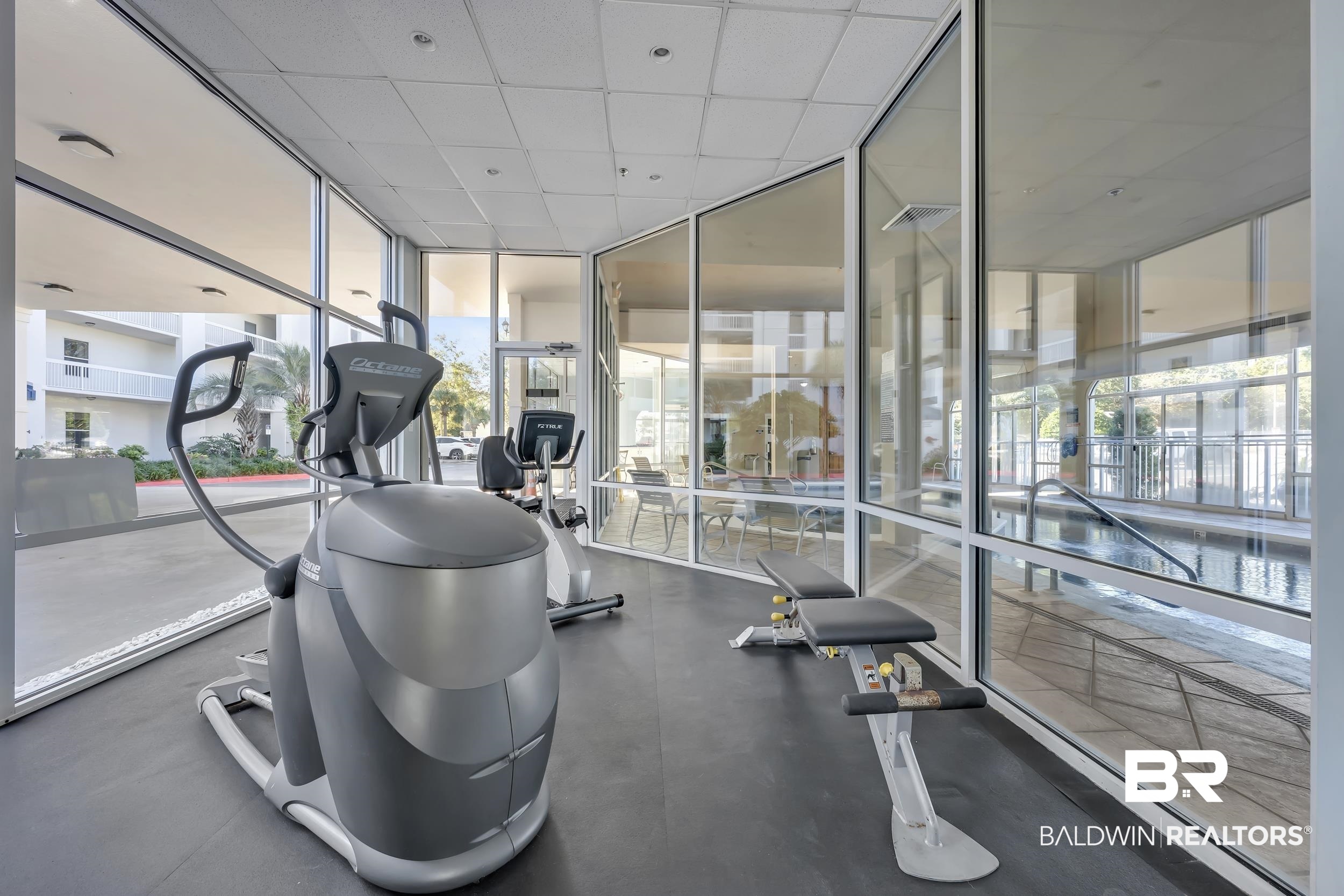 27282 Canal Road, Unit 104 Orange Beach, AL 36561 - Photo 71 of 79 Gym featuring expansive windows and a paneled ceiling
