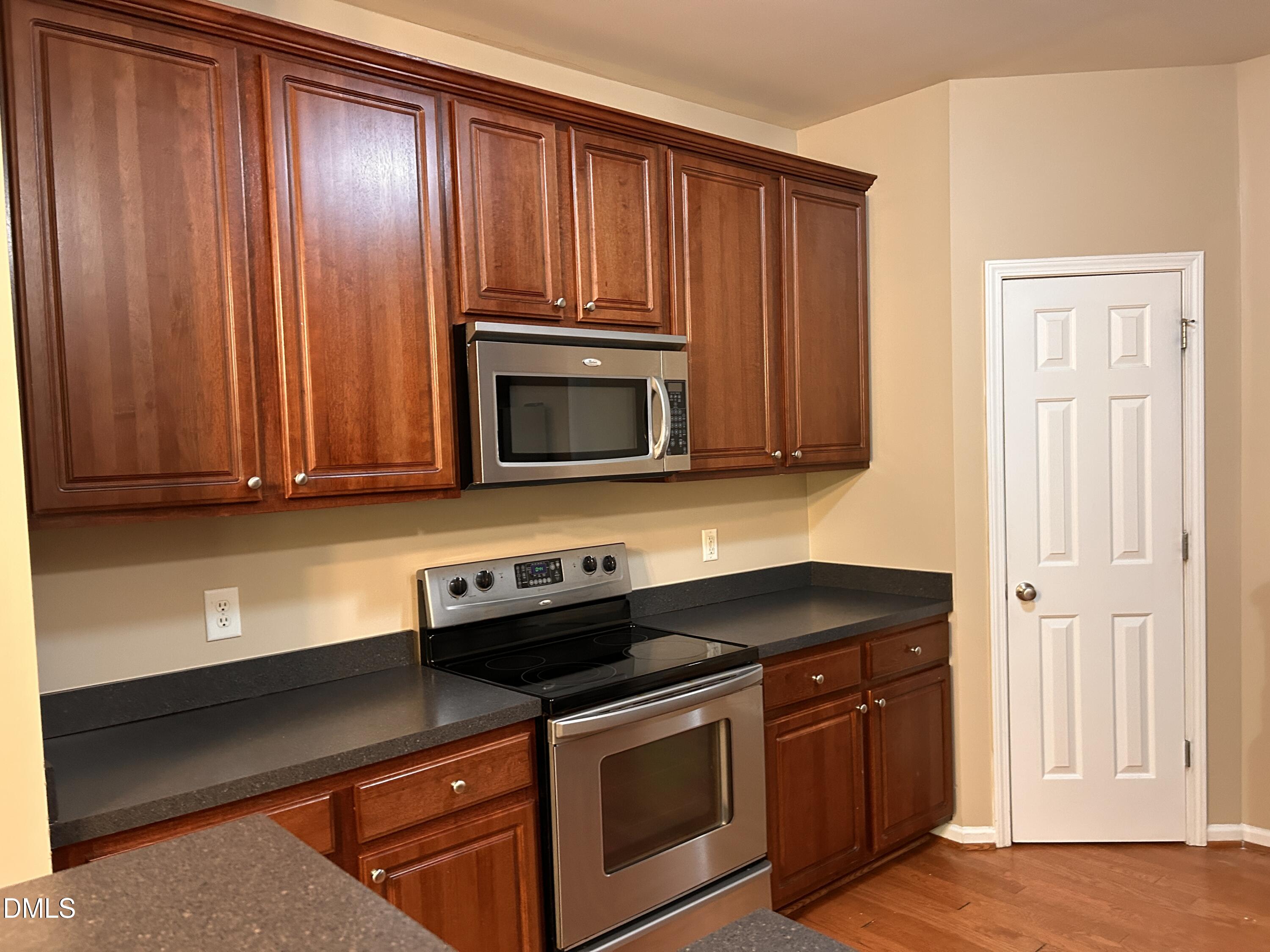 3920 Cane Garden Drive Raleigh, NC 27610 - Photo 8 of 23 a kitchen with granite countertop wooden cabinets and a stove top oven